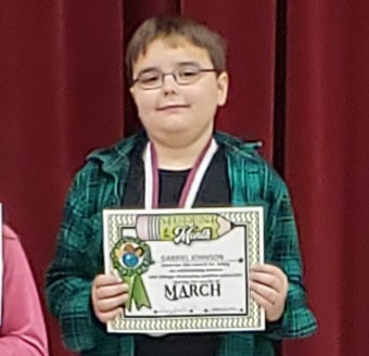 Gabe holds the Student of the Month certificate he earned in March 2019
