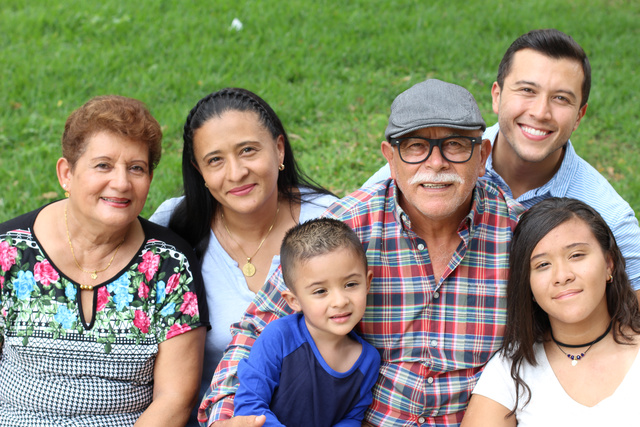 A Latino family including grandparents parents and children pose together