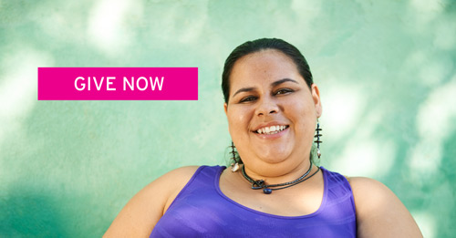 A woman wearing a purple tank top smiles at the camera. Click to go to DRO's Donate page.